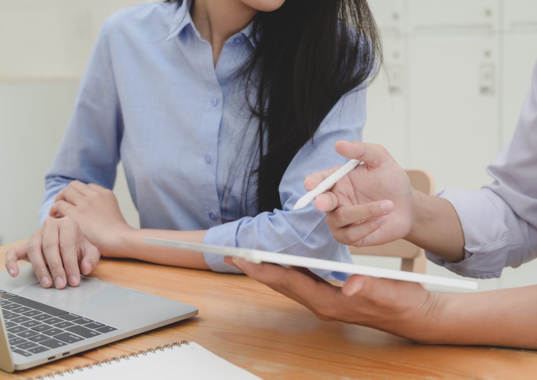 Cropped shot of two business people discussing their project together with laptop computer